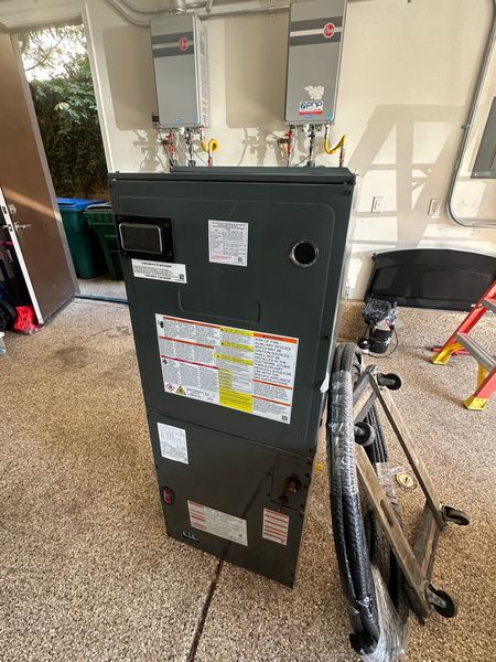 New air handler staged in a residential garage, ready for installation